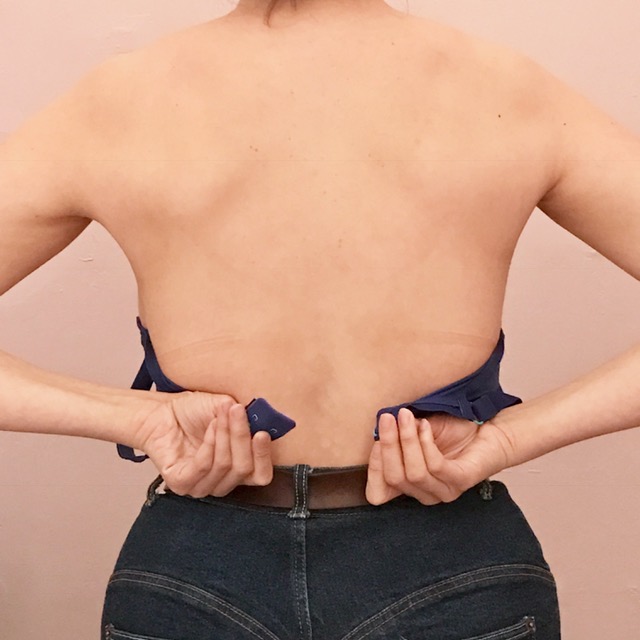a person clasping a bra behind their back