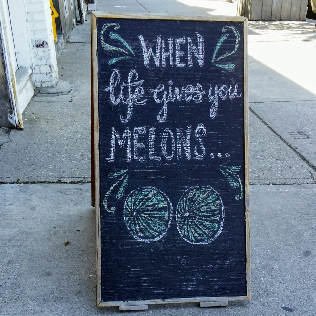 a chalkboard sign that reads "When life gives you melons..."